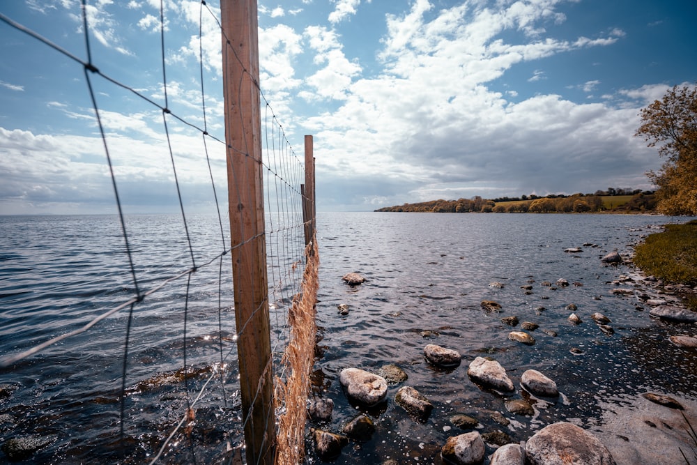 brown wooden post on rocky shore during daytime