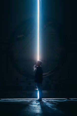 man in black jacket standing in tunnel