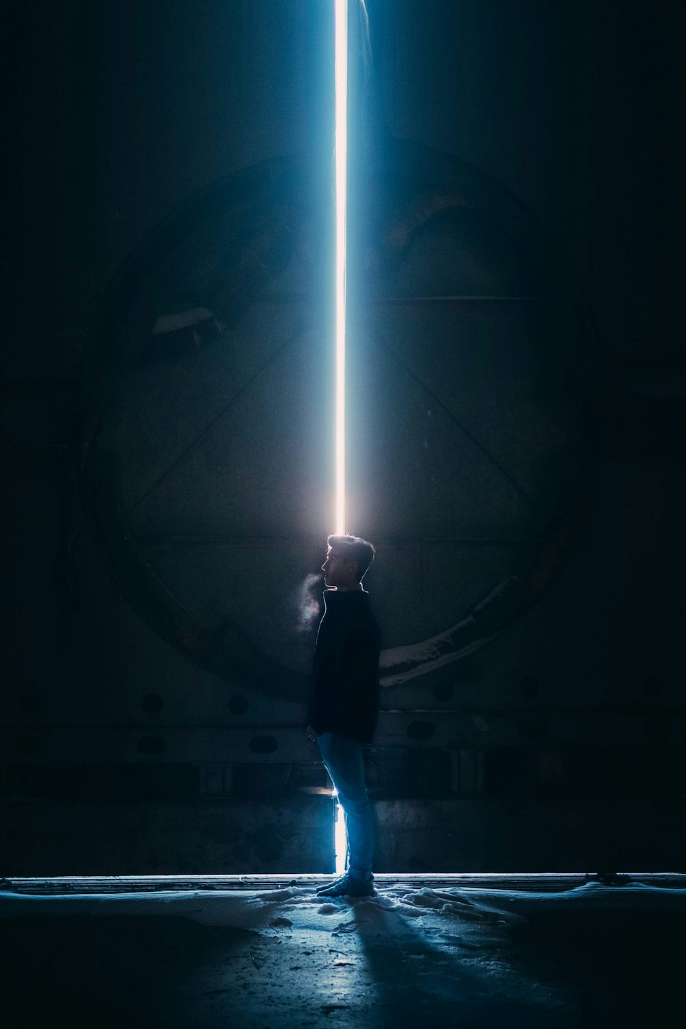 man in black jacket standing in tunnel