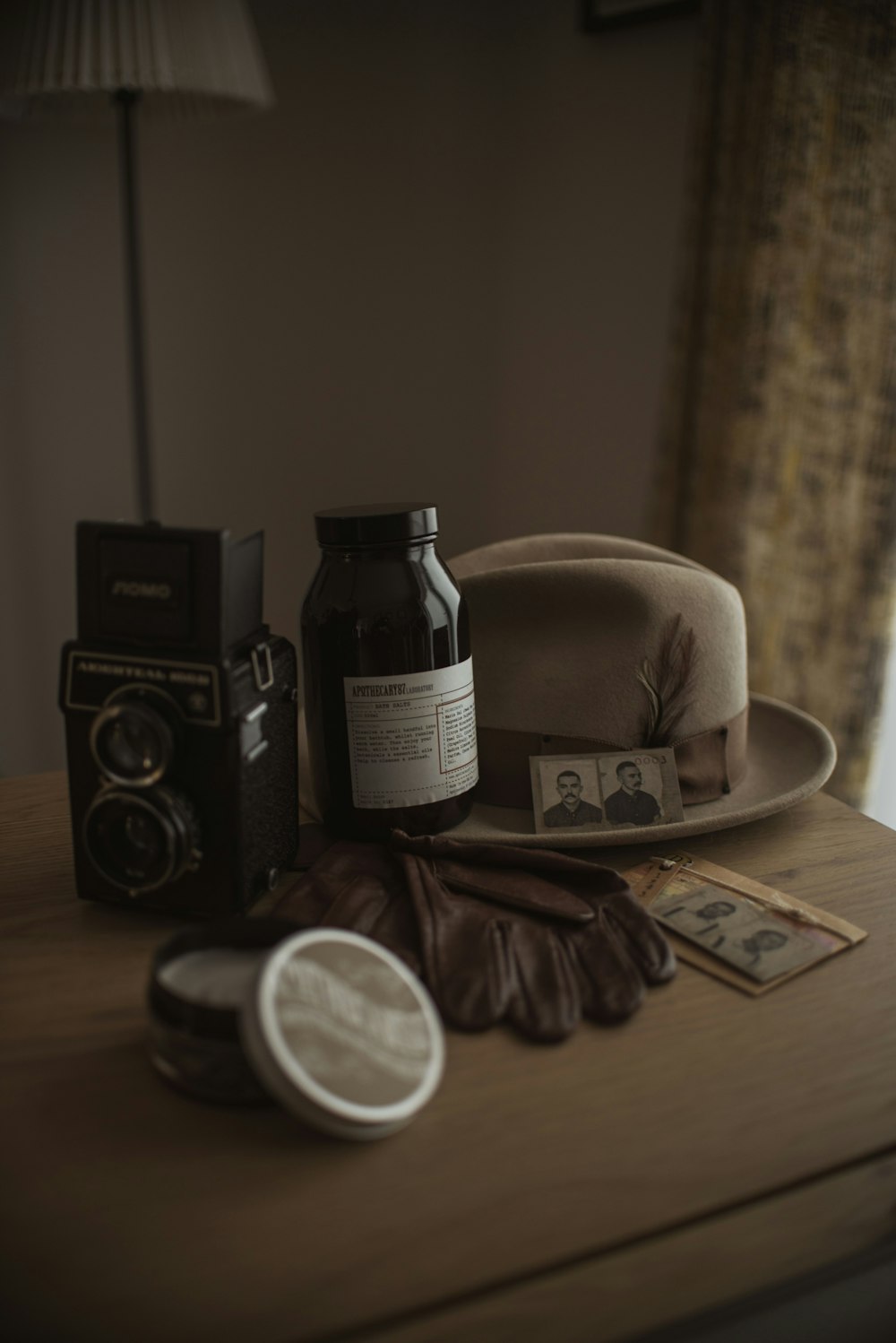 black and white labeled bottle beside brown leather bag on brown wooden table