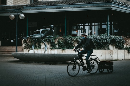 man in black jacket riding bicycle on sidewalk during daytime in Bielefeld Germany