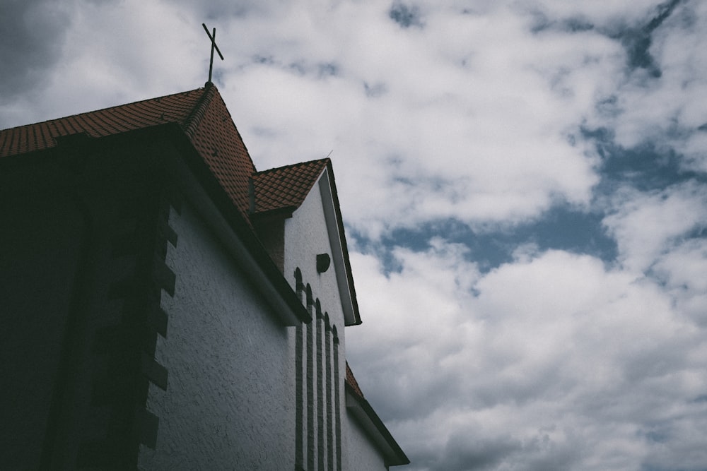 Bâtiment en béton blanc et brun sous des nuages blancs pendant la journée