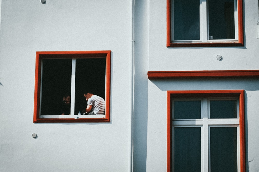 a man is looking out of a window