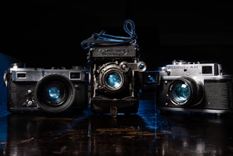 a couple of old cameras sitting on top of a table