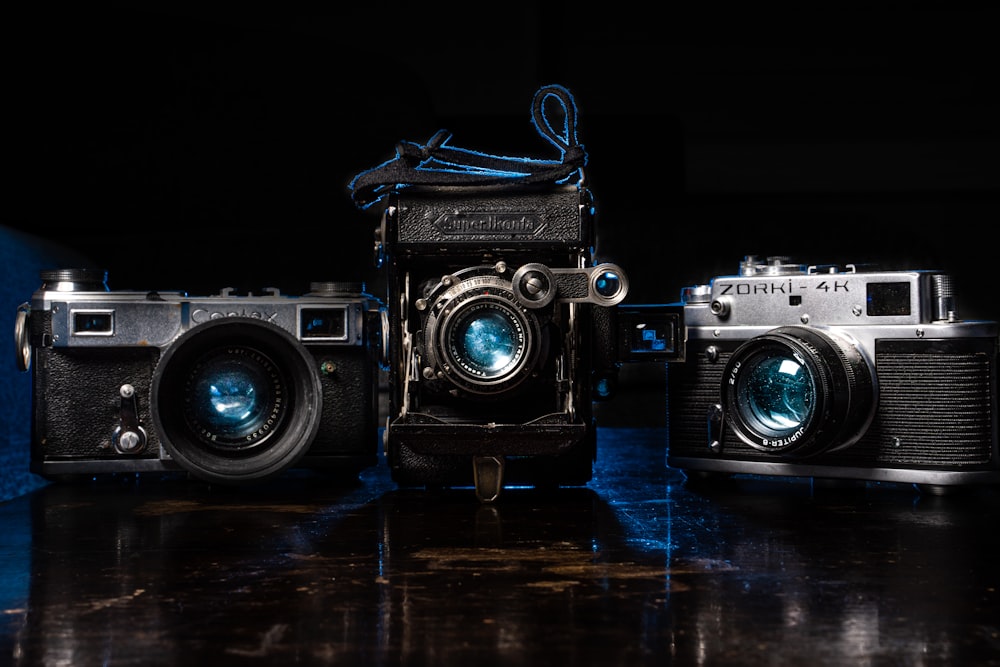 a couple of old cameras sitting on top of a table