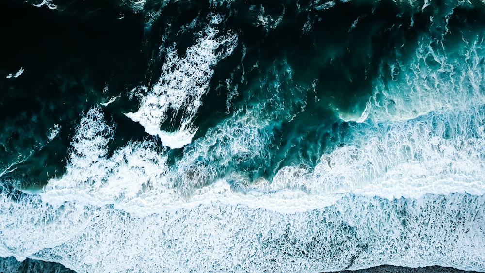 ocean waves crashing on shore during daytime