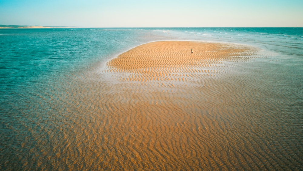 brown sand near body of water during daytime