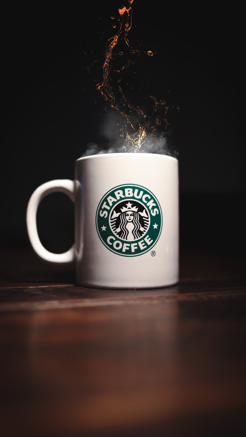 Taza de cerámica blanca de Starbucks sobre mesa de madera marrón