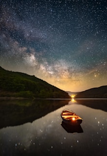 Nighttime view of a boat illuminated by soft lights under a star-filled sky