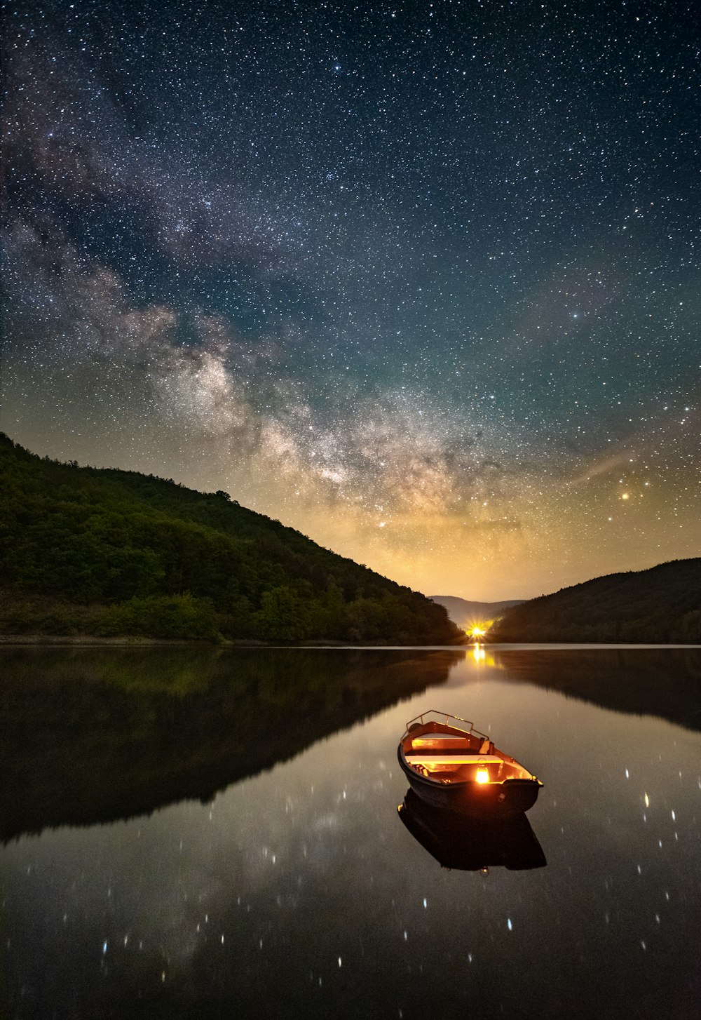 boat on lake near mountain during night time