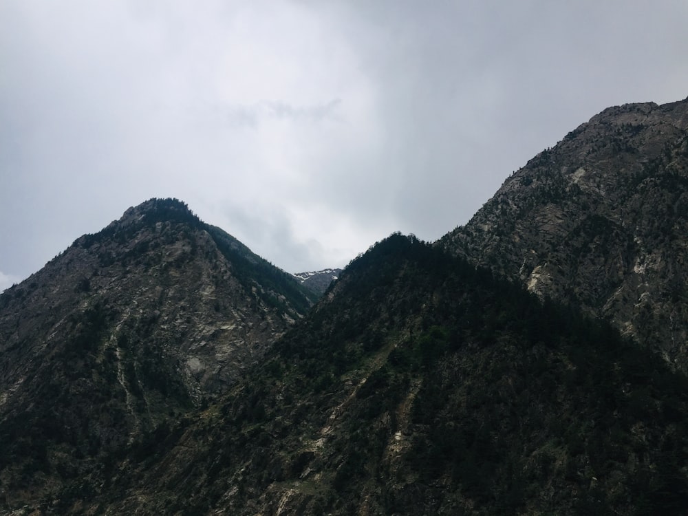 green and black mountain under white clouds