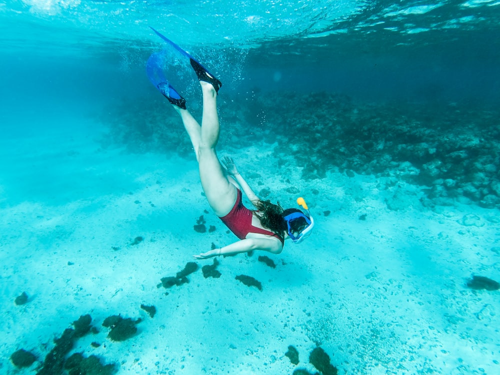 femme en bikini bleu et noir nageant dans la mer