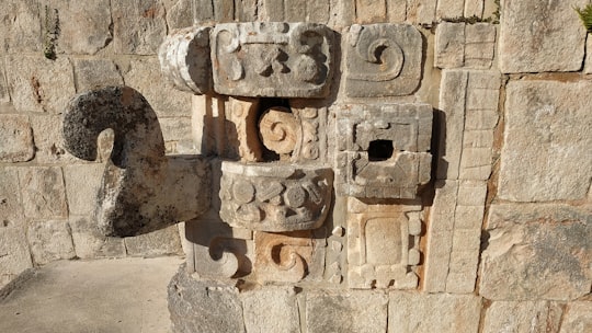 brown concrete blocks on gray sand during daytime in Uxmal Mexico