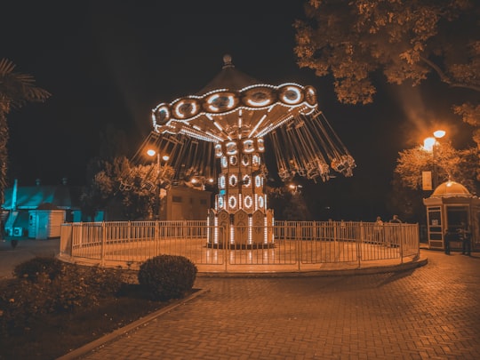 lighted carousel surrounded by trees during night time in Baku Azerbaijan