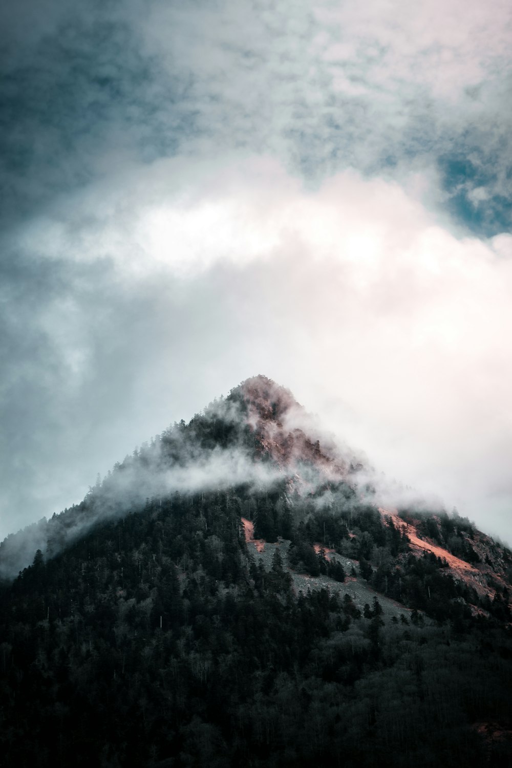 montagne noire et blanche sous des nuages blancs