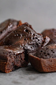 Close-up of a moist chocolate zucchini cake with a rustic backdrop.