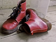 Tall boots leaning against a rustic brick wall.