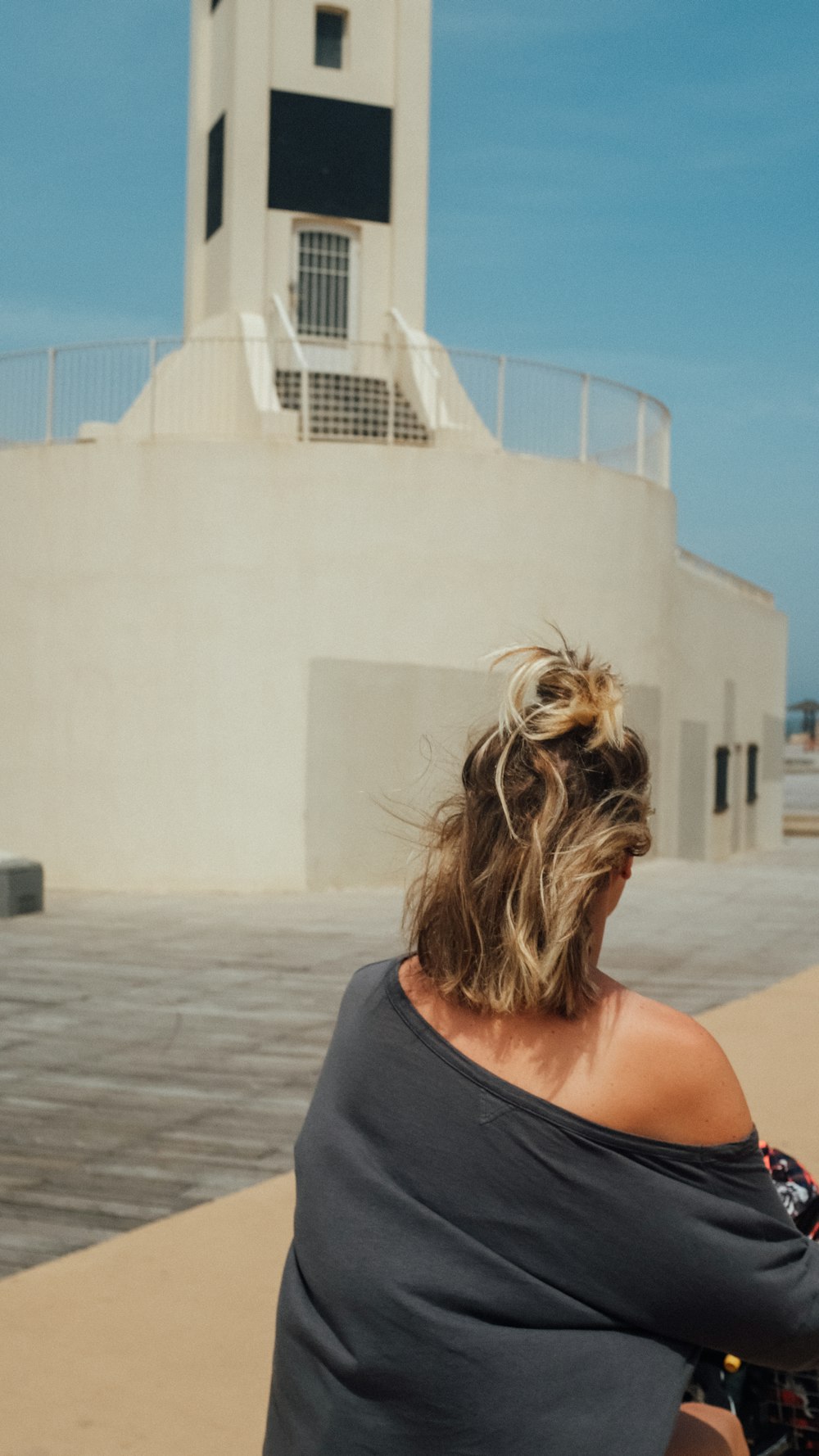 woman in black tank top standing near white concrete building during daytime