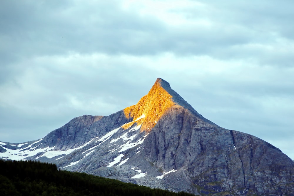 Montaña marrón y blanca bajo nubes blancas durante el día