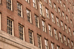 Exterior view of a historic brick home with fresh paint and repaired windows.