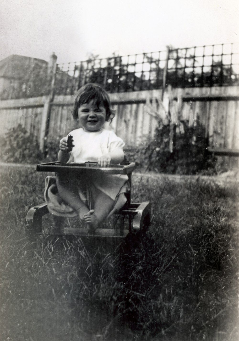 grayscale photo of child riding on cart