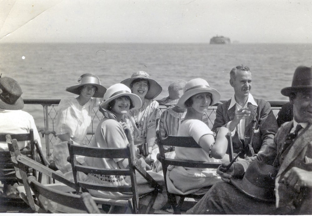 grayscale photo of men sitting on bench