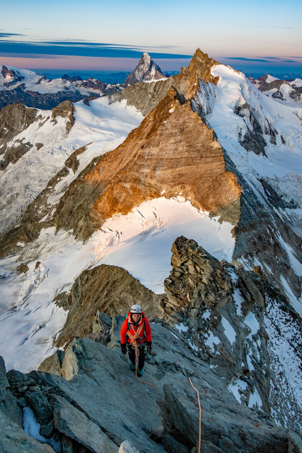 person in red jacket and black pants standing on snow covered ground