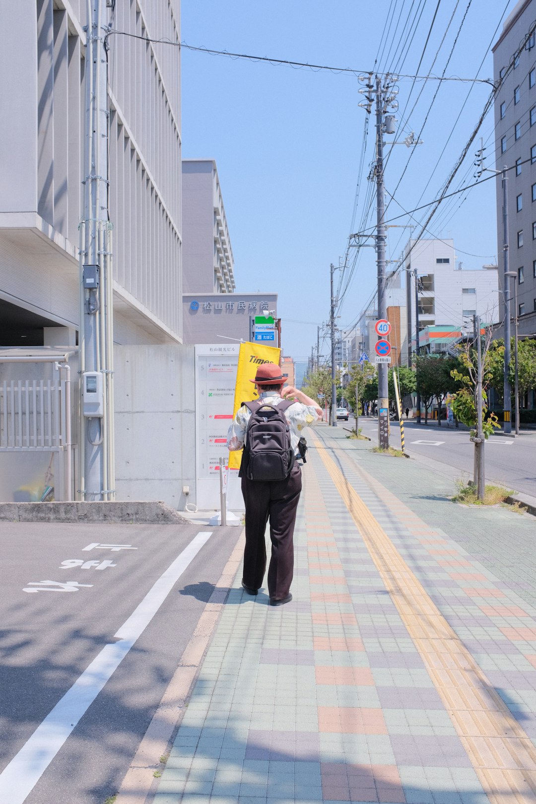 man in black jacket and black pants walking on sidewalk during daytime