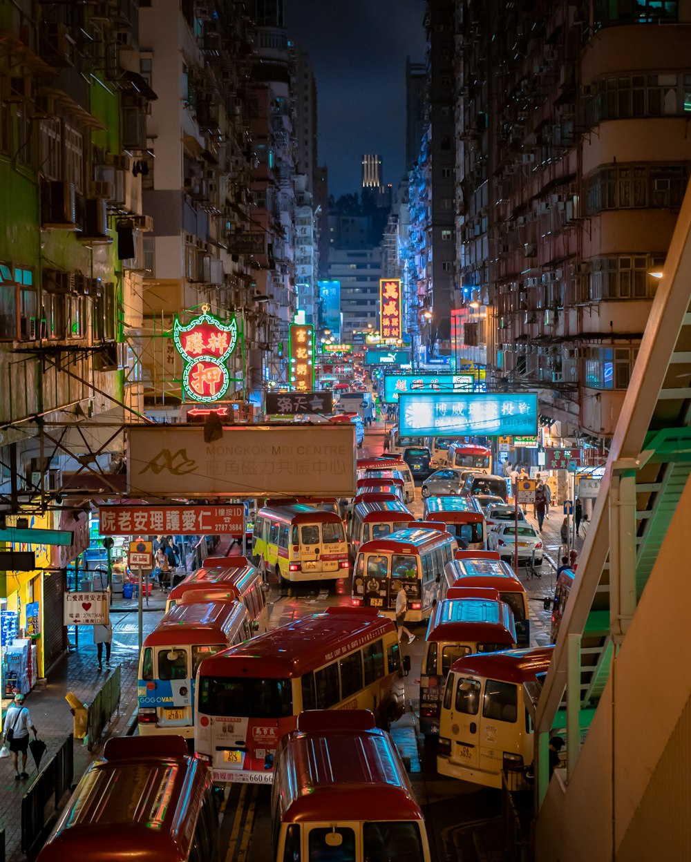 cars on road between high rise buildings during night time