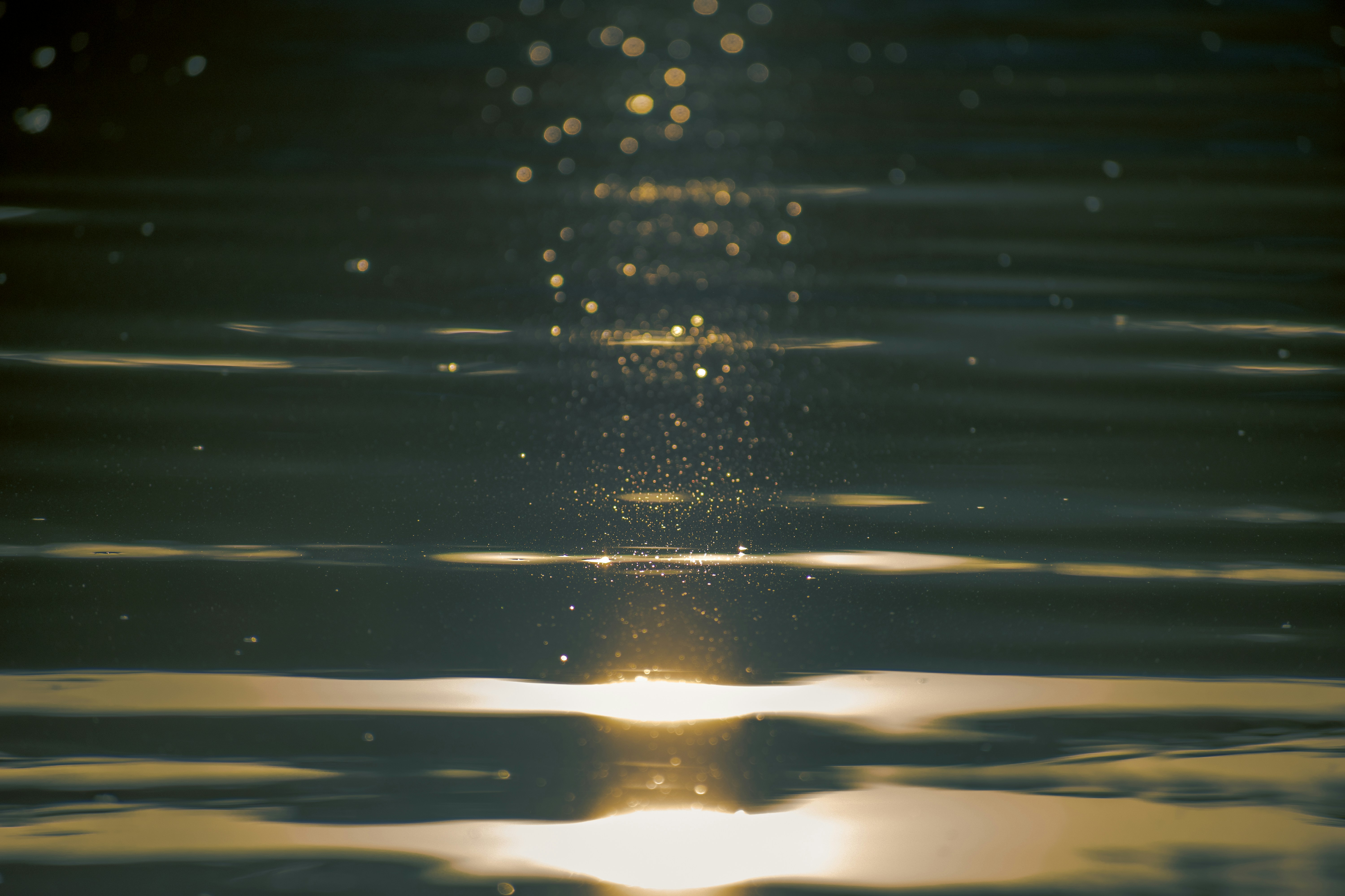 water droplets on body of water during daytime