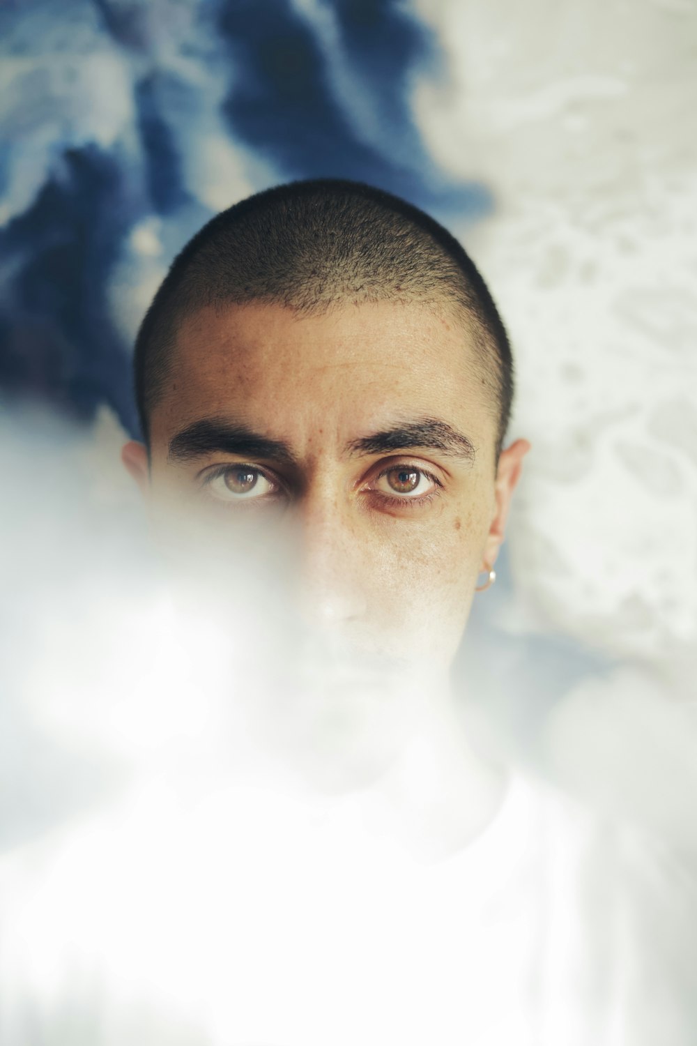 man in white shirt with white smoke in his face