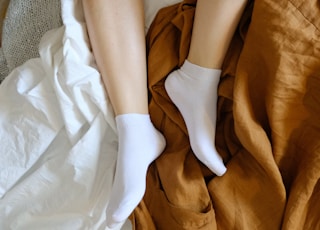 person wearing white socks on brown textile