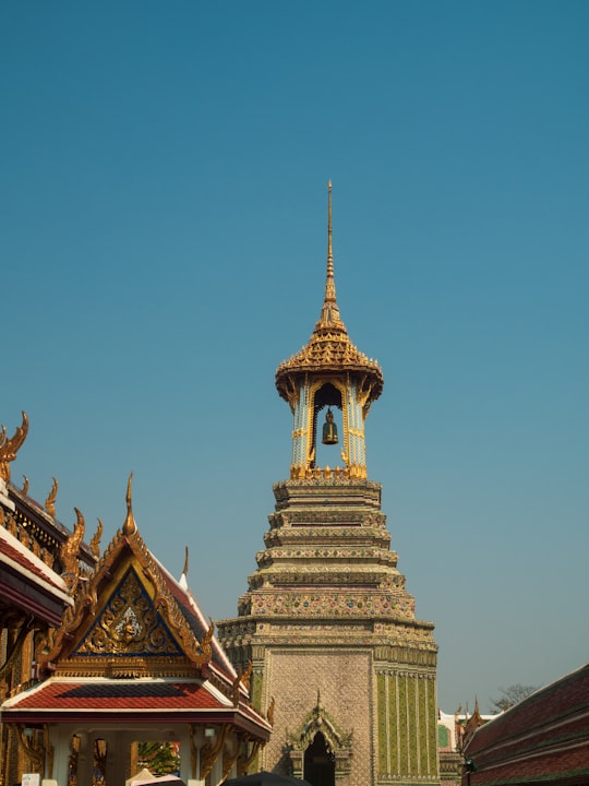 gold and brown concrete building under blue sky during daytime in Temple of the Emerald Buddha Thailand