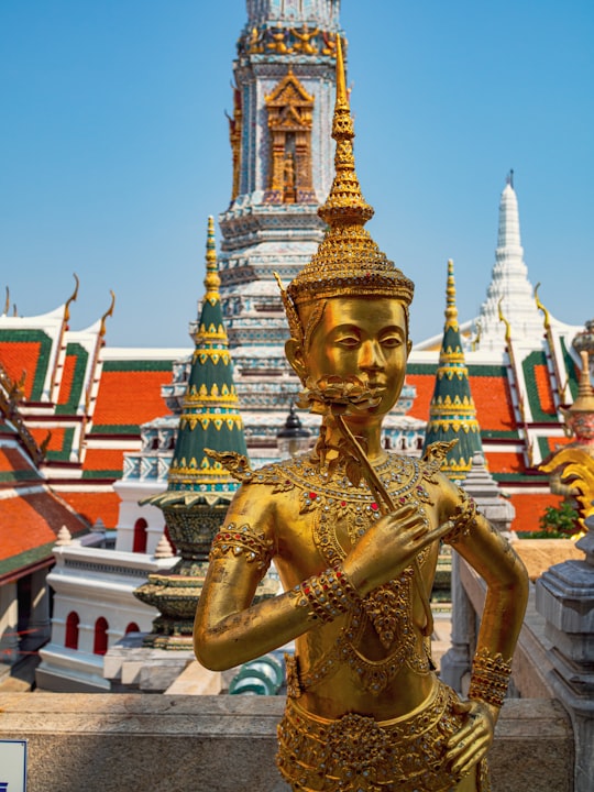 gold hindu deity statue during daytime in Temple of the Emerald Buddha Thailand