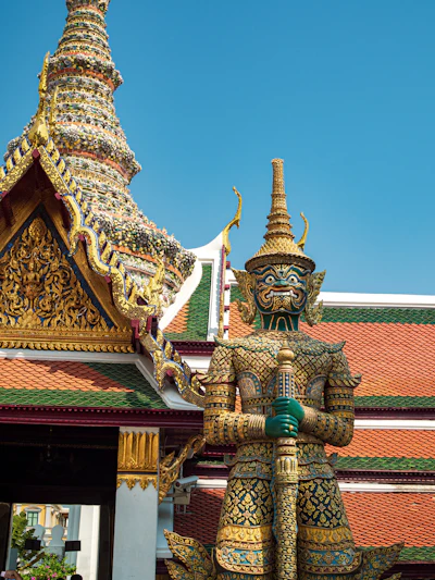 A gold Bangkok shrine under blue sky