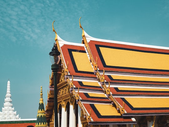 brown and white concrete building under blue sky during daytime in Temple of the Emerald Buddha Thailand