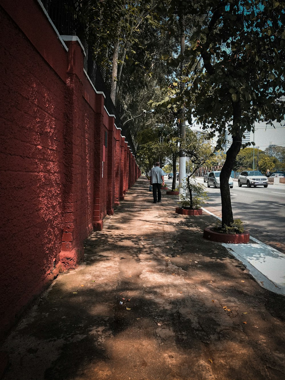 Mur de briques rouges avec des arbres sur le côté