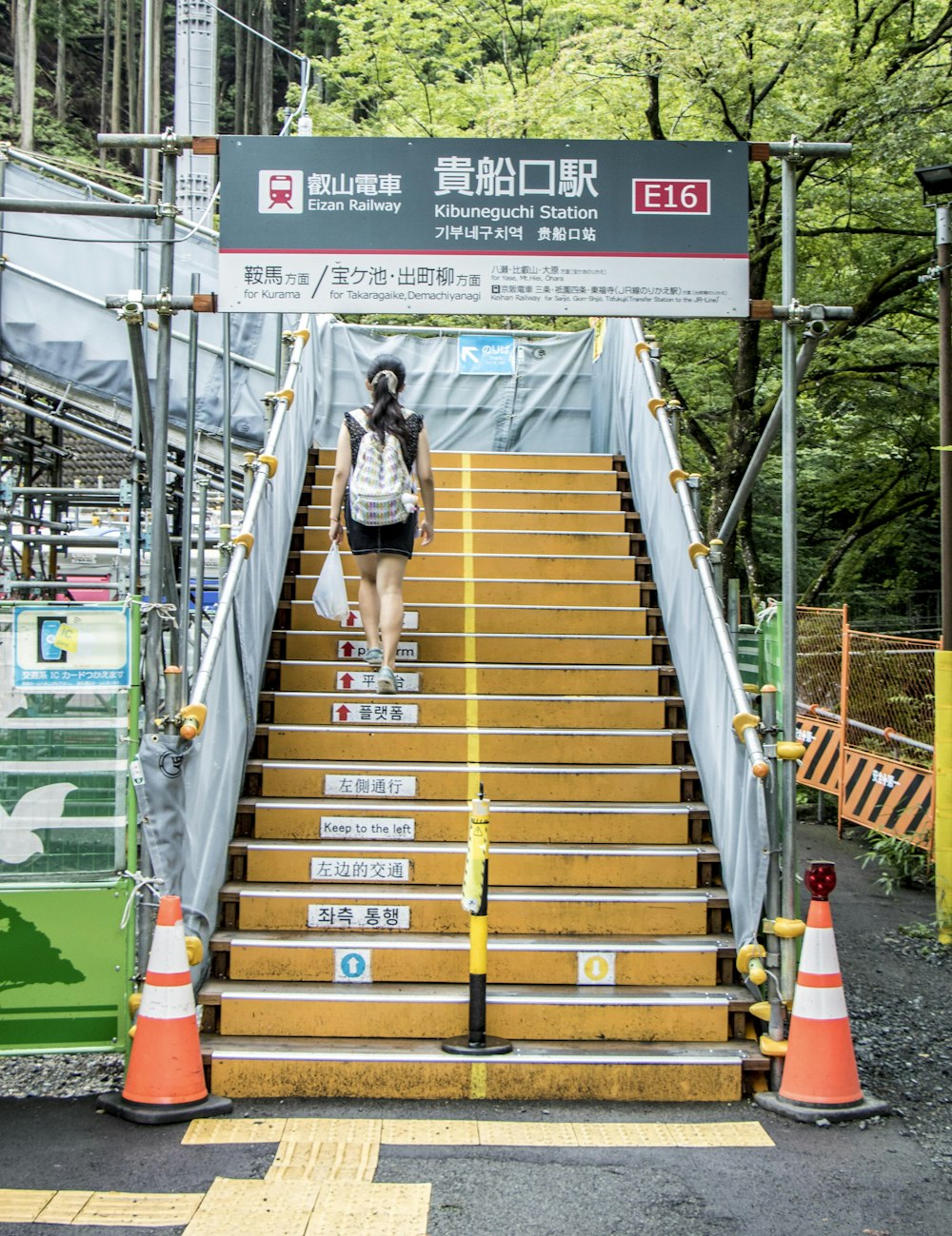 woman in black tank top and black shorts walking on brown wooden stairs