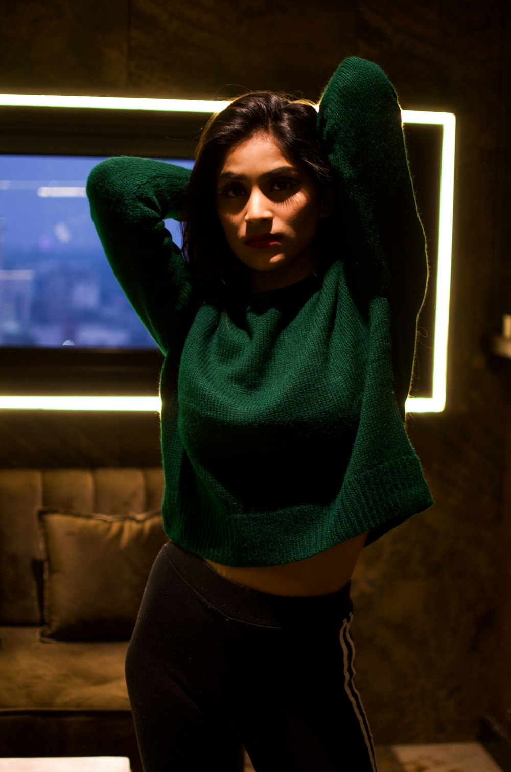 a woman in a green sweater posing for a picture