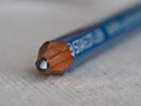 Close-up of a premium wooden sketching pencil resting on textured drawing paper.