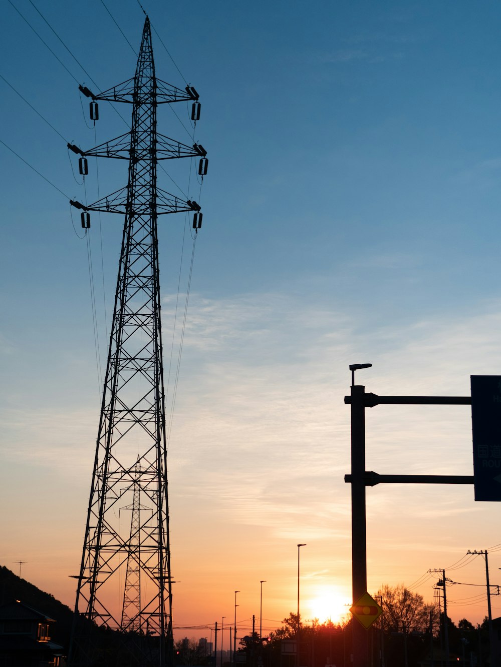 silhouette of electric post during sunset