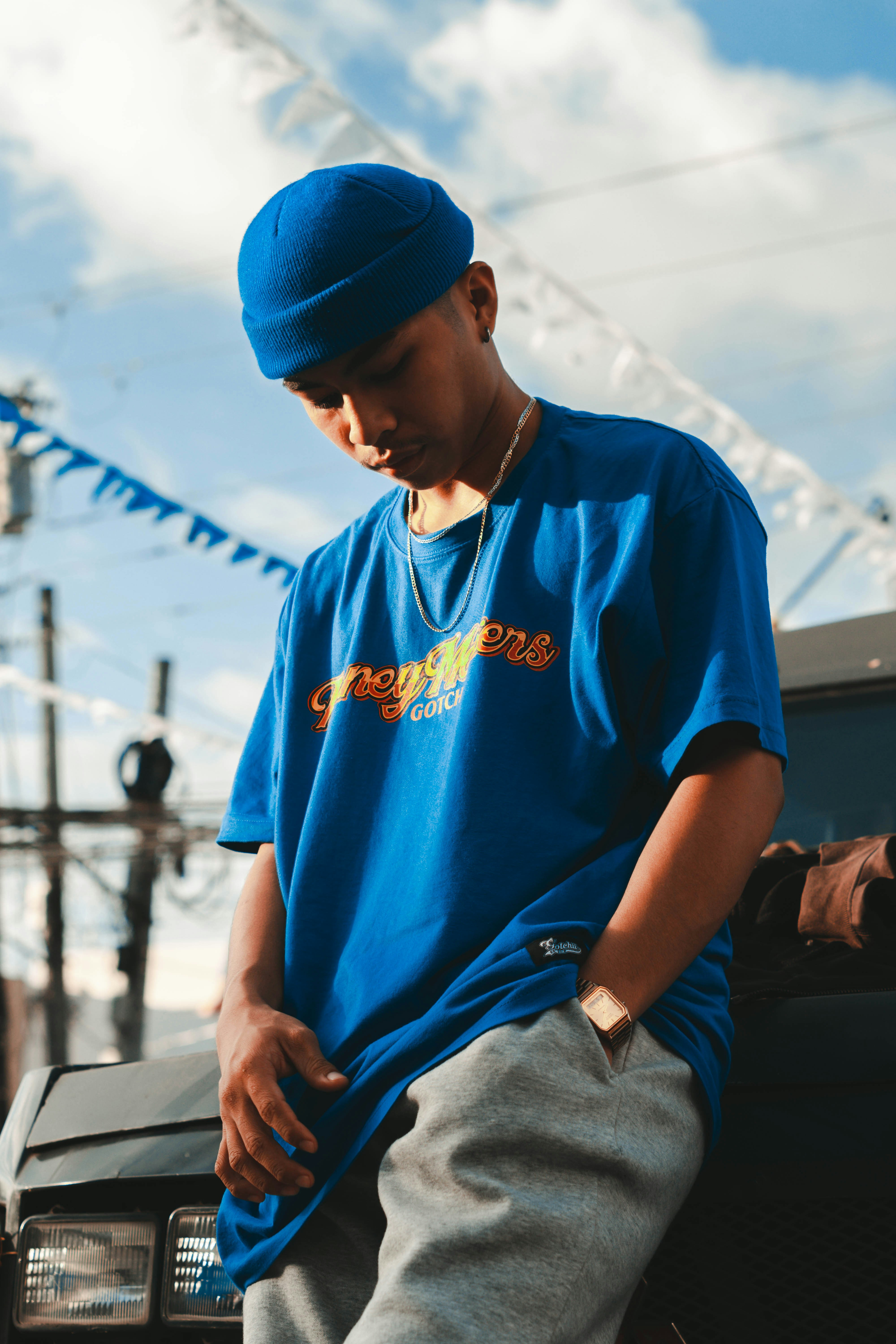 Pria dengan kaos leher kru biru dan jeans denim abu-abu duduk di kursi hitam