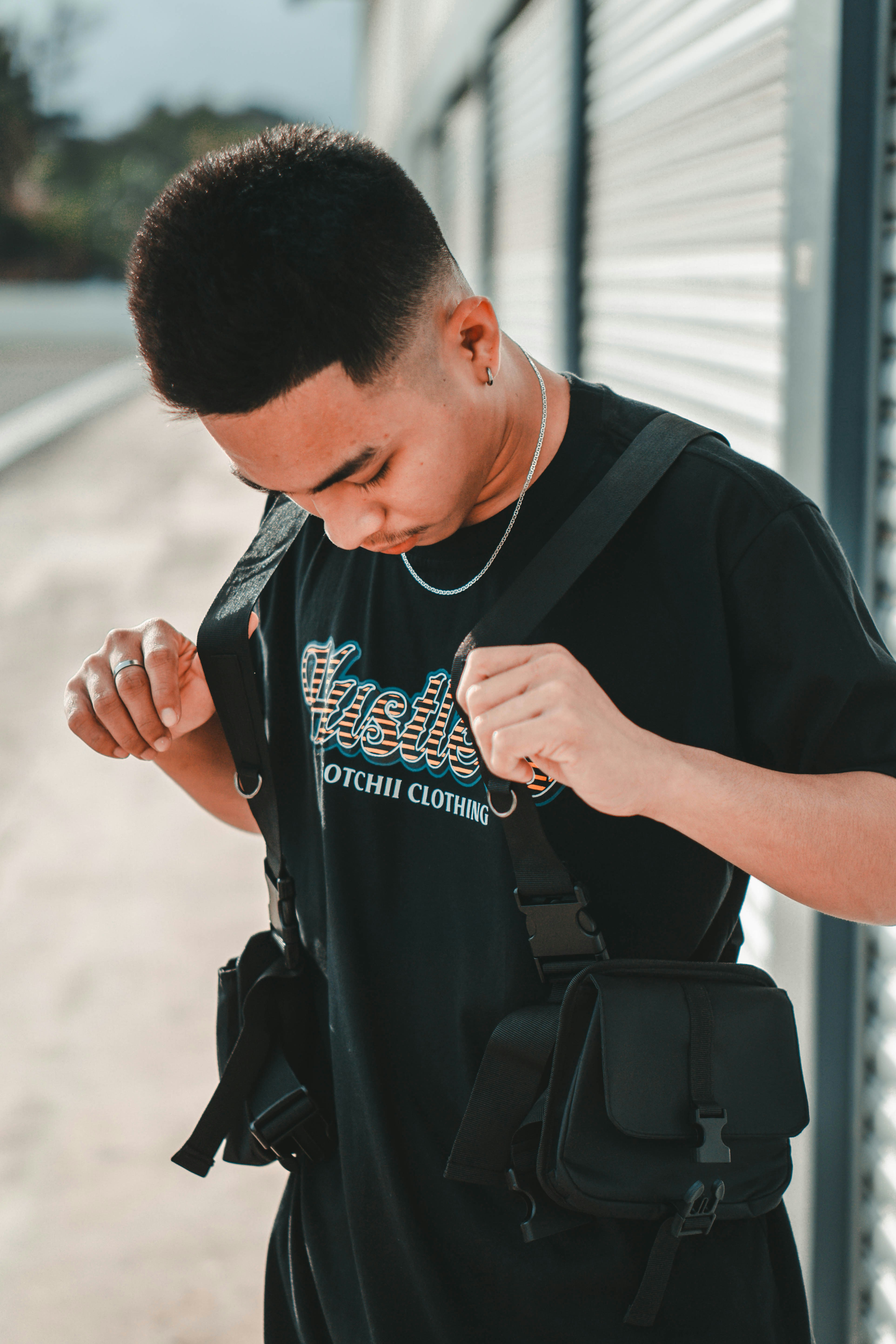 Pria berbaju leher kru hitam memegang ransel hitam