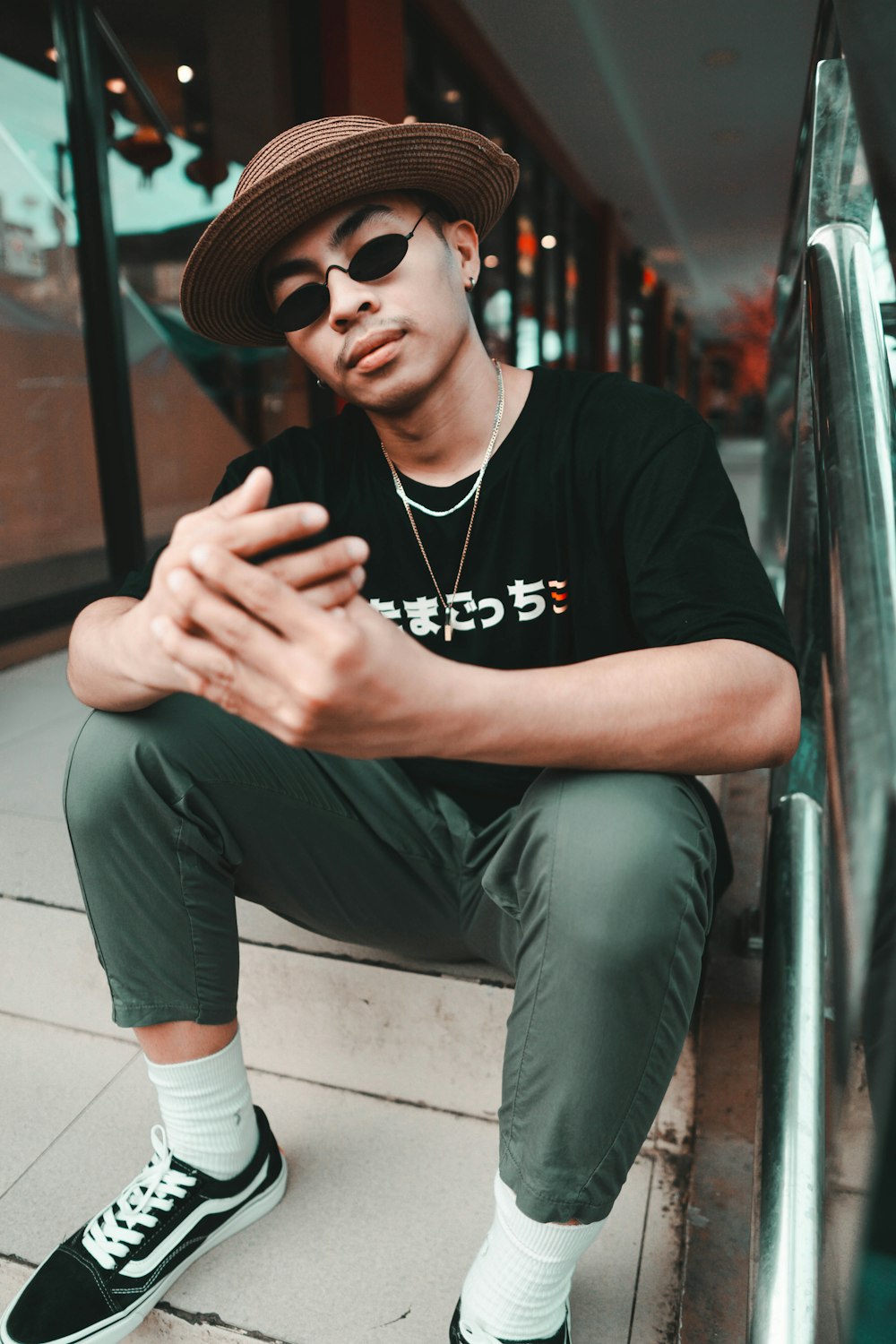 man in black crew neck t-shirt and gray pants sitting on gray bench