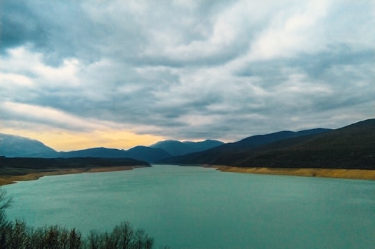 green lake near mountain under cloudy sky during daytime in Kukës Albania