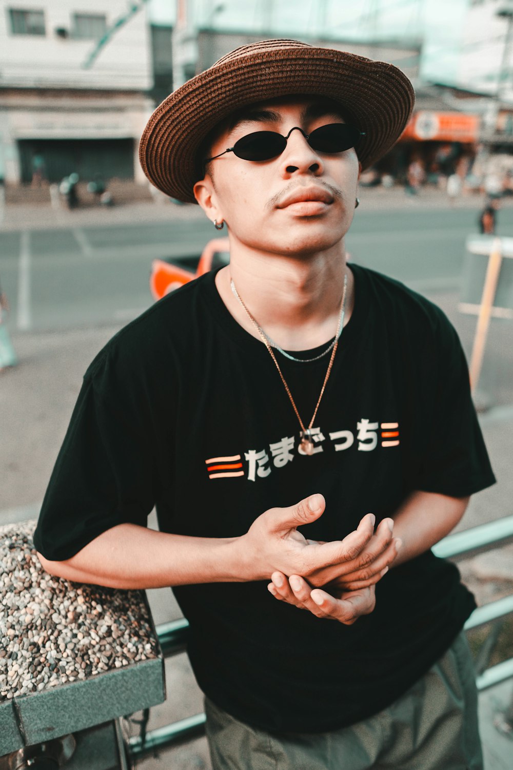 man in black crew neck t-shirt wearing black sunglasses and black hat