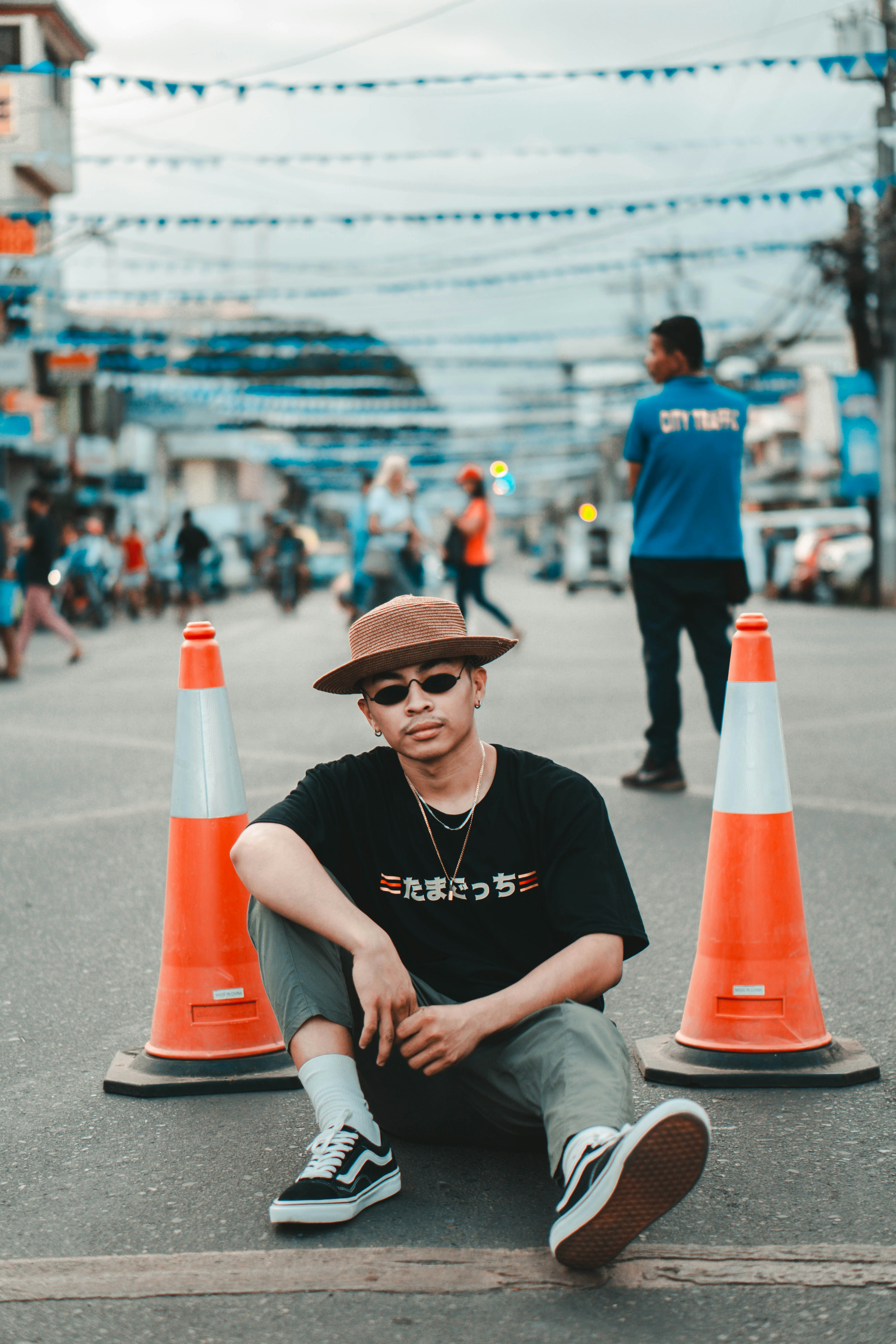 man in black crew neck t-shirt and gray shorts sitting on red and white traffic