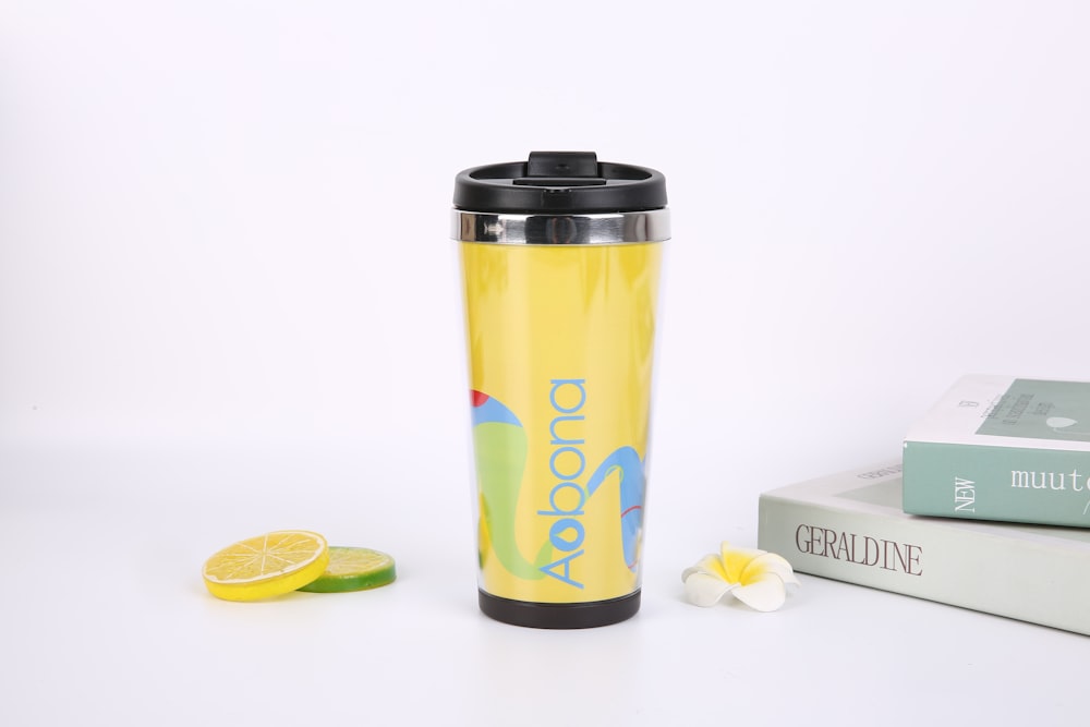 yellow and black travel mug beside white and black box