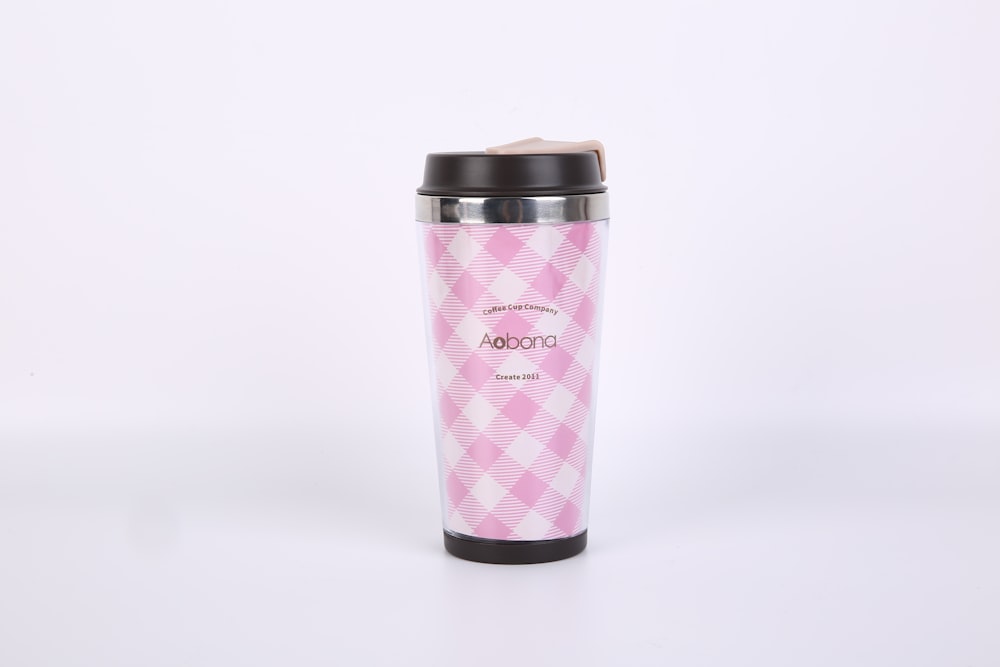pink and black tumbler on white table
