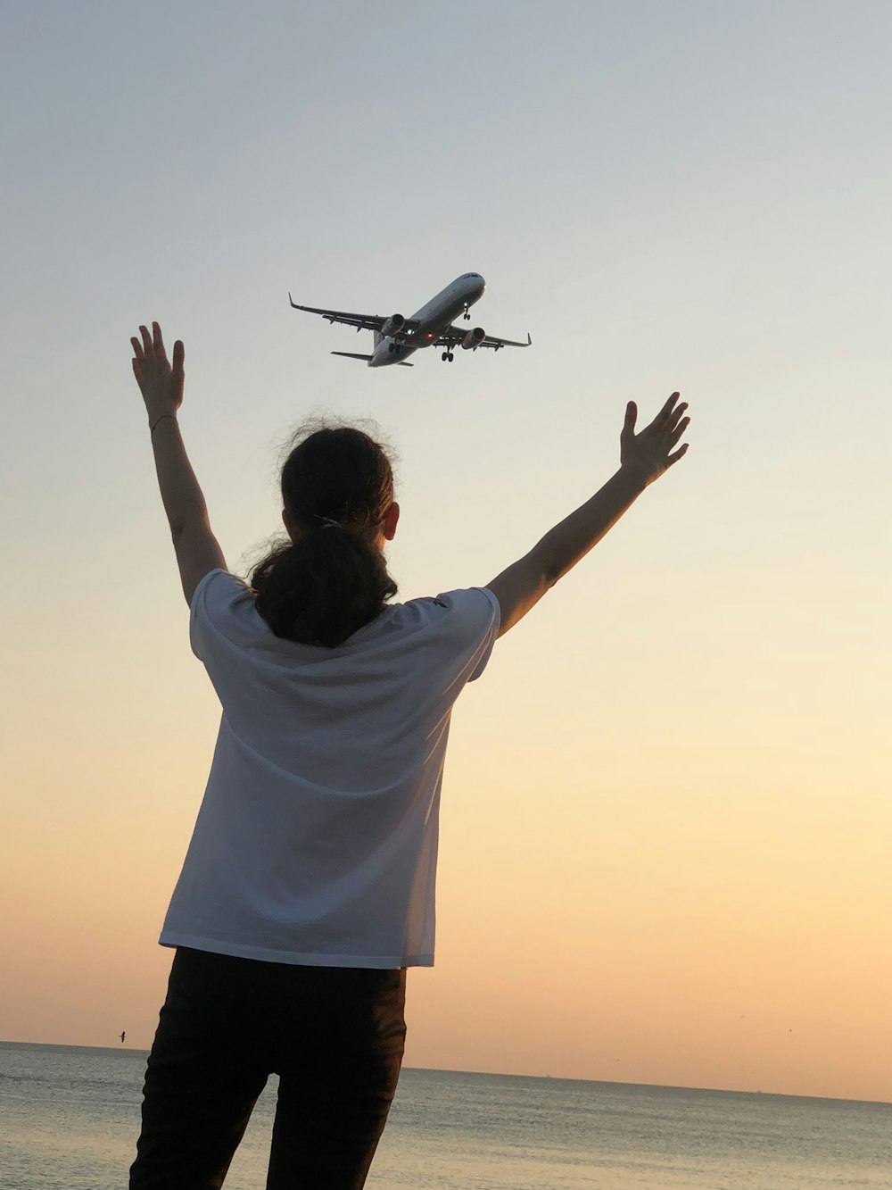 man in white shirt and black shorts holding white airplane